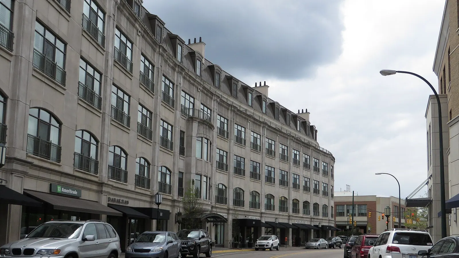 Downtown Birmingham, MI streetscape along Woodward Avenue with upscale shops, sidewalk dining, and Shain Park nearby