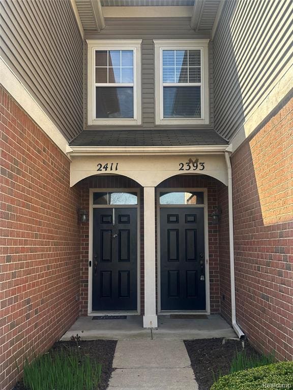 Covered front entry with brick surround and arched transom window