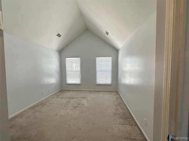 Primary bedroom with vaulted ceiling and large windows